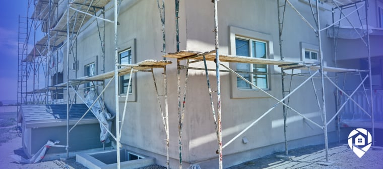 Exterior home renovation in progress showing scaffolding during a real estate investment property rehab.