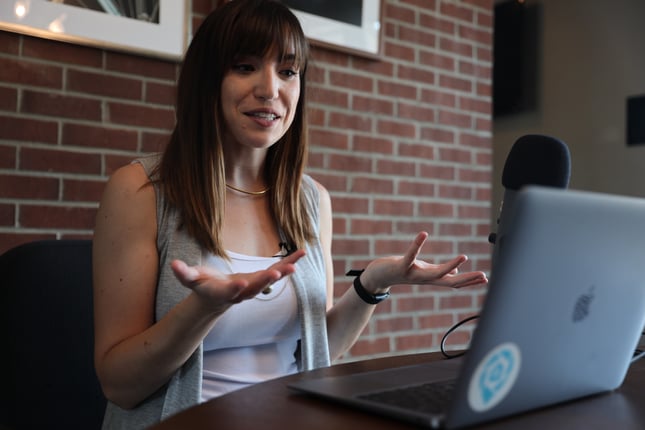 Girl holding up her hands while looking at a computer