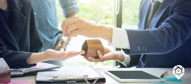 Real estate agent handing house keys to investor after closing a property deal.