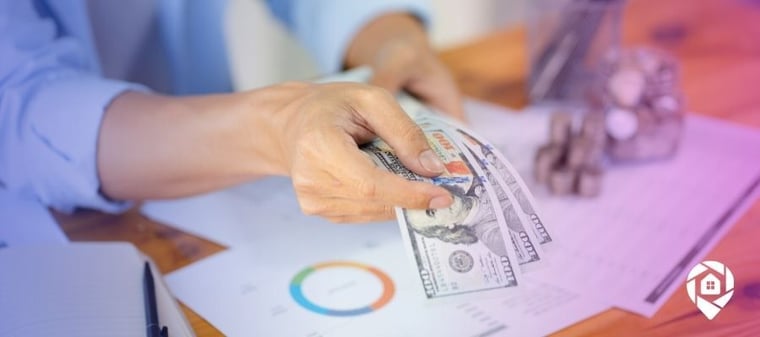 A hand holding out money showing the potential for bonus depreciation on a rental property.