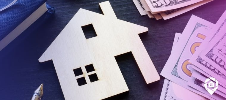 An image of a wooden house on a desk with a notebook and hundred and fifty dollar bills for the "Finding the Right Types of Real Estate Investments for You" blog header.