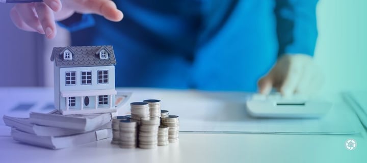 a good faith deposit sitting next to a small house on a desk