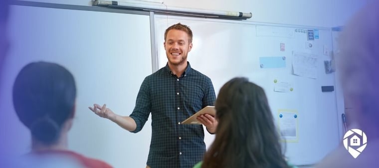 Smiling teacher presenting to a classroom, representing starting a real estate wholesaling business while working full-time.