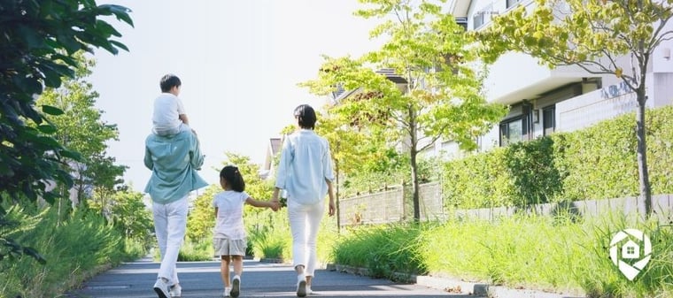 Family walking in a residential neighborhood near modern real estate homes.
