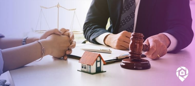 House and a gavel on a table with people in the background for finding preforeclosures near me.