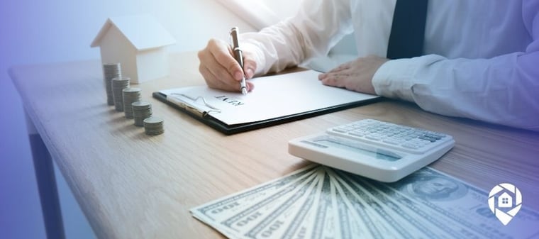 Investor signing real estate agreement with money, calculator, and property model on desk for passive income strategy.