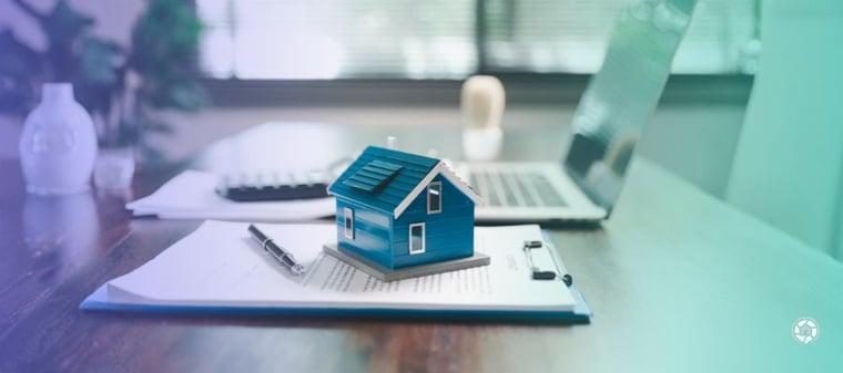 a tiny house on top of a clipboard on a desk