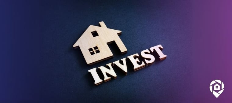 A cut out of a wood house with the word invest underneath it to symbolize house investments in a downturn economy.